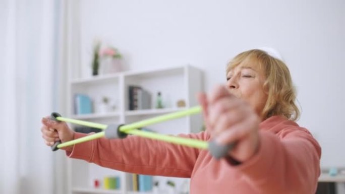 老年女性用伸缩带锻炼，积极的生活方式，在家健身