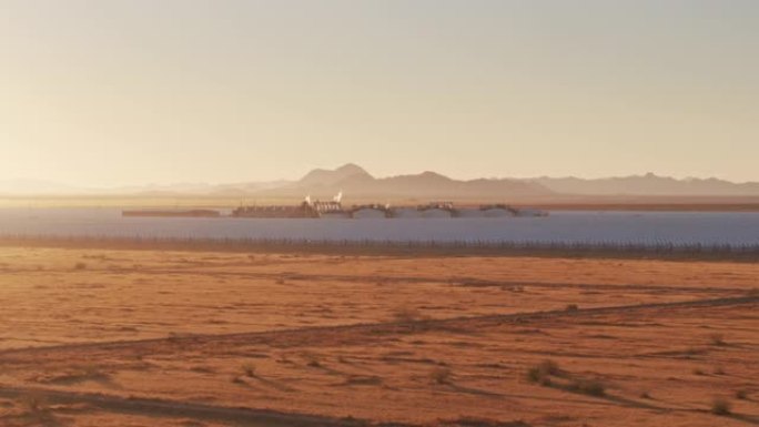 黎明日出时贫瘠的沙漠景观和抛物线槽太阳能发电厂