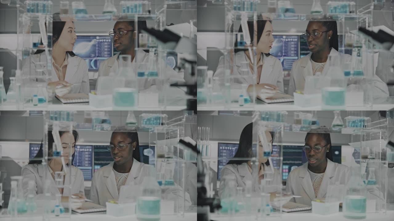 从事显微镜工作的非洲和亚洲女性科学家。浏览实验室玻璃器皿