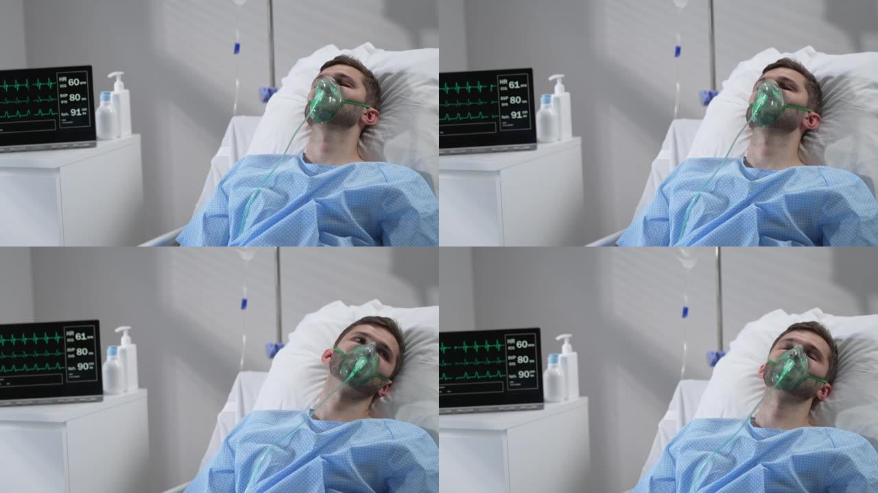 该名男子戴着氧气面罩躺在医院的床上，恢复了意识。连接到呼吸和心率监测器躺在医院的床上，闭着眼睛