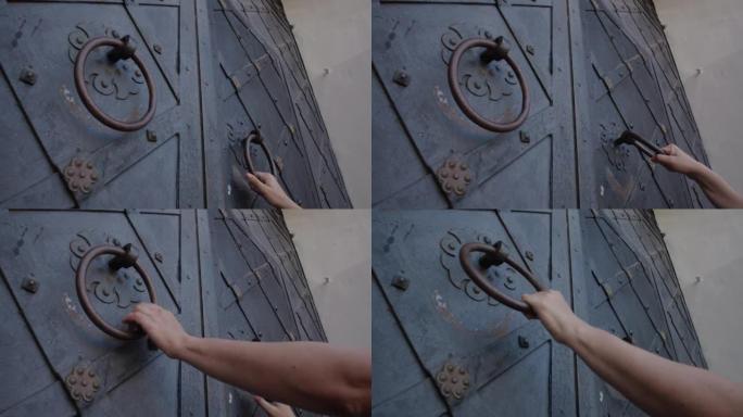 妇女的手试图打开铁艺门并拉动把手
