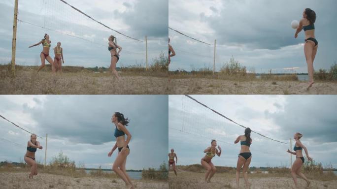 暑假，两队年轻女子在沙滩上打排球，慢动作射击，苗条而运动的女士