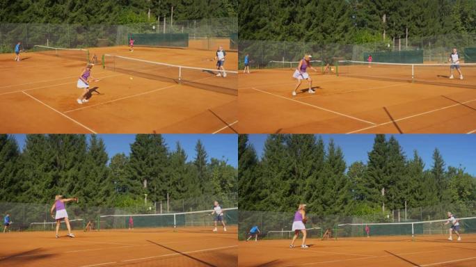 CS高级女子和男子在阳光下在室外球场打网球