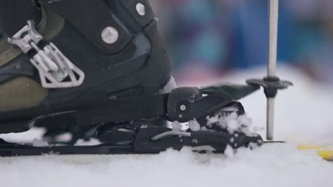 女性滑雪靴穿滑雪板的侧视图特写。在白雪上滑雪设备中无法辨认的女子滑雪者的脚。