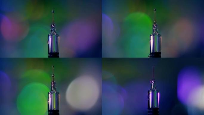 滴落在玻璃疫苗的现代注射器针头上的药滴