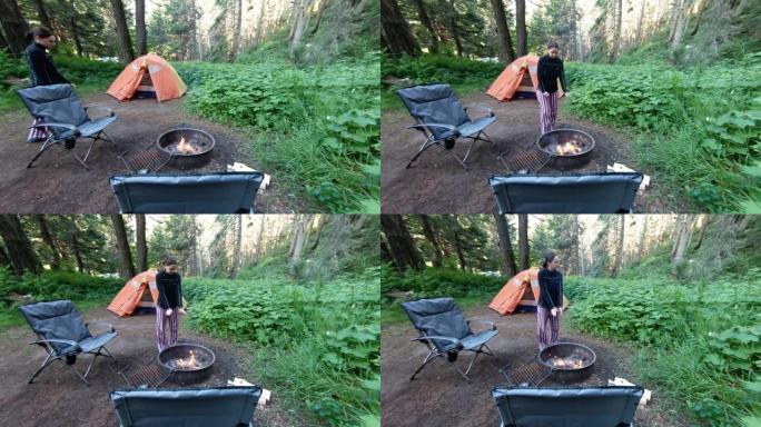 女人站在树林里的室外火坑旁
