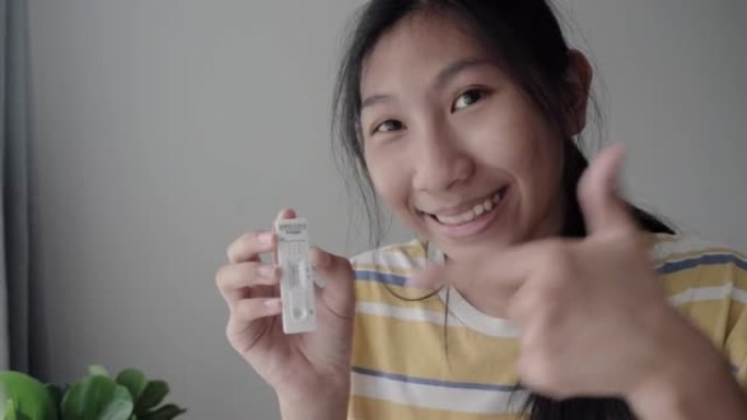亚洲女孩用智能手机在家里制作新冠病毒快速检测视频，然后在网上课堂上发给老师，健康的生活方式理念。