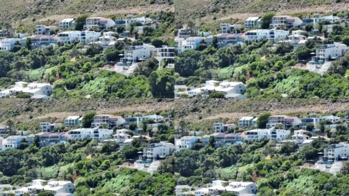 斜坡上有绿色植被的度假公寓豪华住宅的滑动和平移镜头。热带暑假目的地。南非