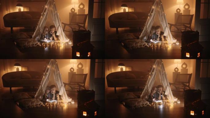 童年快乐的时刻，小男孩和女孩晚上在房子的房间里玩玩具帐篷