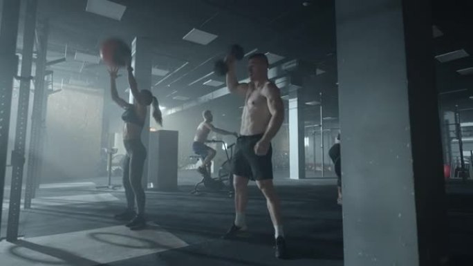 男运动员和女运动员正在健身房进行激烈的训练，一群举重运动员在做练习