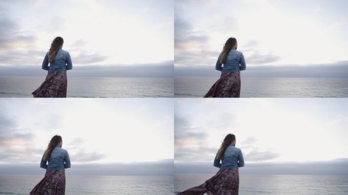 一个女人从悬崖边望向大海的特写镜头