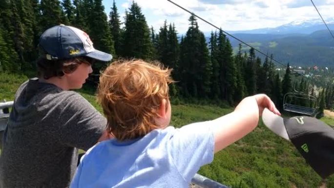年轻男孩在不列颠哥伦比亚省华盛顿山上空乘坐升降椅