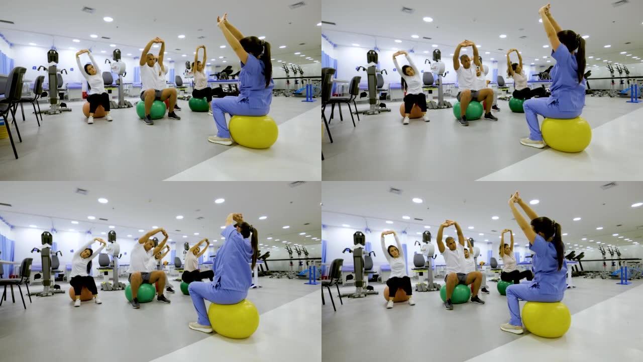 一组患者在康复中心进行健身球锻炼时遵循物理治疗师的指示