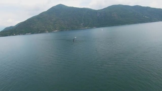 空中无人机拍摄了一名男子在山上的湖上冲浪的风