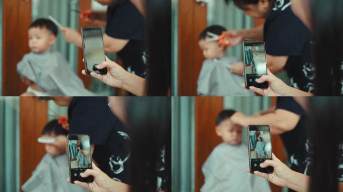 POV拍摄: 母亲在剪头发时向儿子拍照