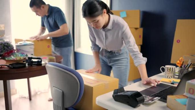 中小企业检查订单的亚洲企业主，在家工作。