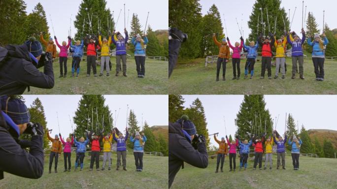 摄影师拍摄了一个徒步旅行团体的照片，将他们的步行杆举到空中