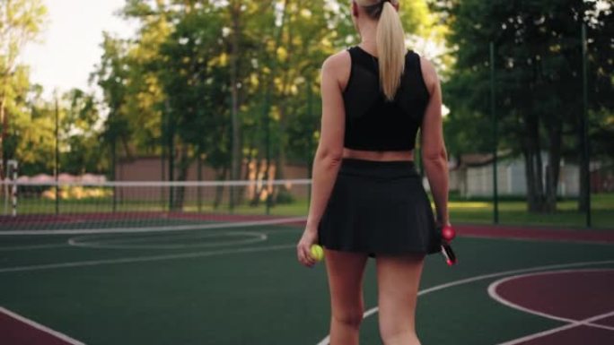 自信的网球运动员女人要上场，苗条的金发女郎的后视图