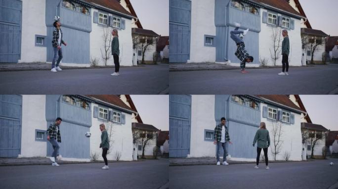 两人穿着便服在街上踢足球和耍花招