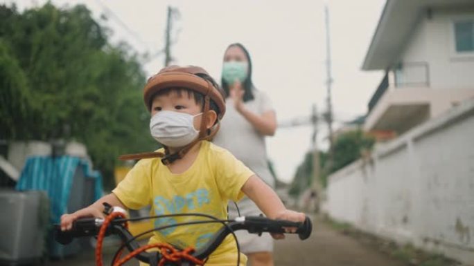 蹒跚学步的小男孩在户外骑自行车玩得开心