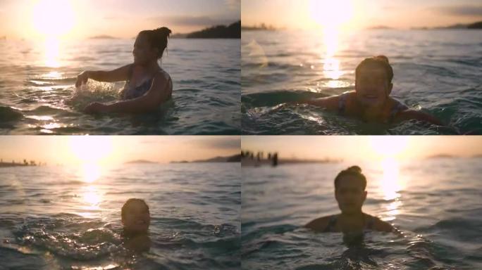 日落时快乐的年轻女子在海里游泳