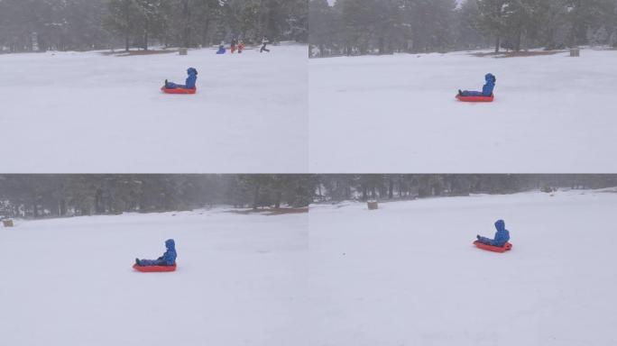 在下雪天，傲慢的男孩手放在脖子后面，滑下滑雪橇