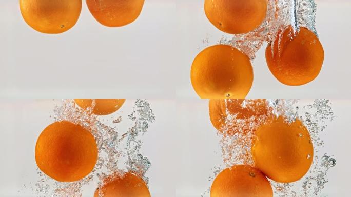 SLO MO LD整个橘子在白色背景下落入水中