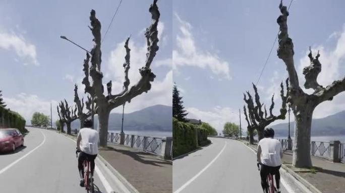 在湖泊附近的道路上，公路自行车手的垂直镜头