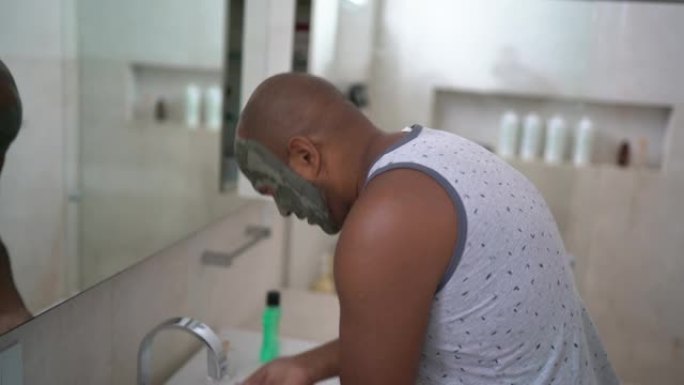 成熟男人去除面部泥面膜在家浴室洗脸