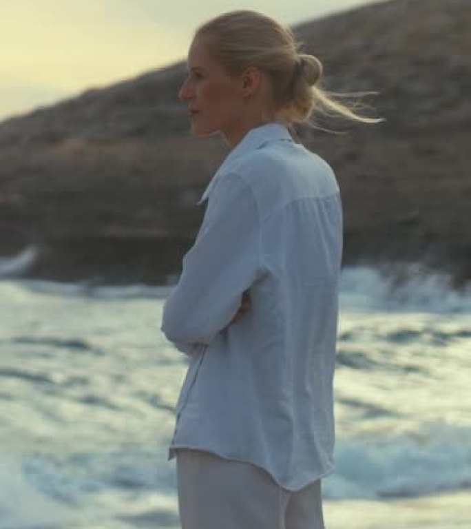 独自站在海滩上的女人。眺望遥远的大海垂直视频