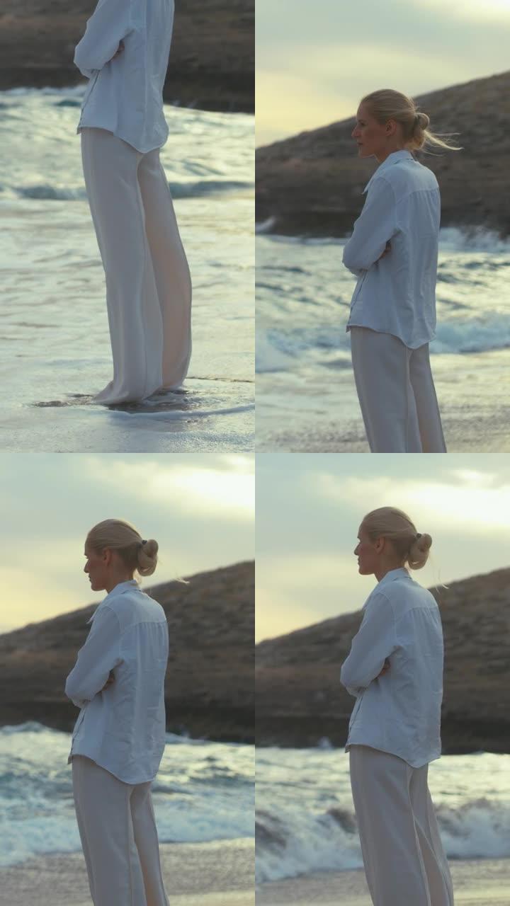 独自站在海滩上的女人。眺望遥远的大海垂直视频
