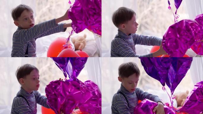 着迷的自闭症高加索男孩在家室内玩放气的气球。古玩快乐放松的孩子出生异常享受玩具休闲的侧视图肖像。自闭