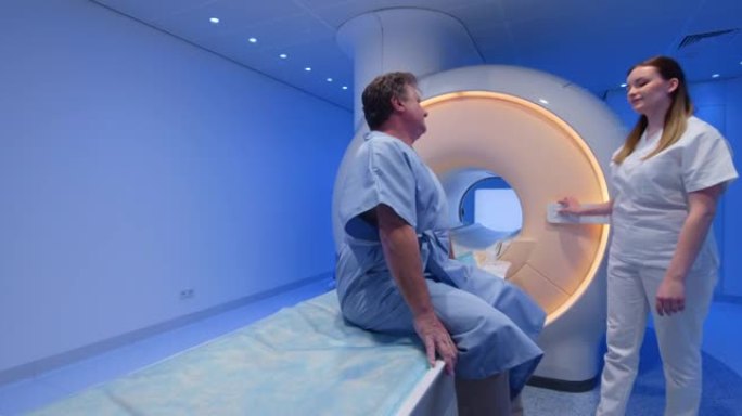 DS女性放射学技术专家在MRI扫描前与男性患者交谈