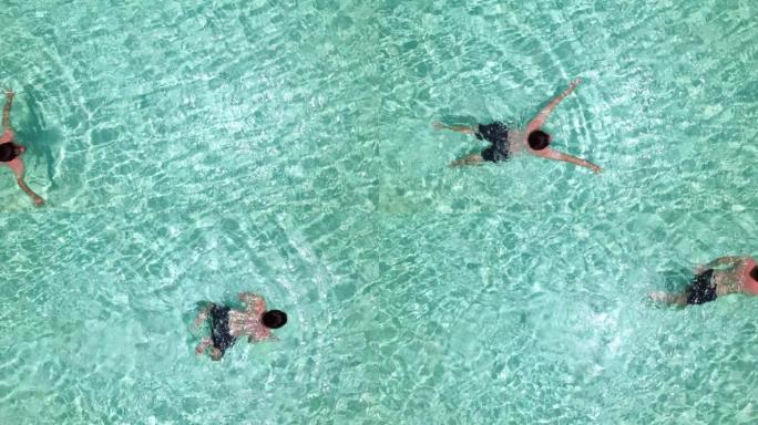 俯视图，亚洲男子在一个大游泳池游泳。
