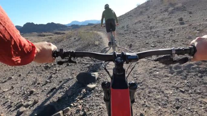 沿着沙漠小径骑e山自行车的第一人称视角
