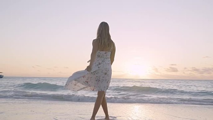 海滩漫步。穿着夏装的女人在热带海岸线上享受日落