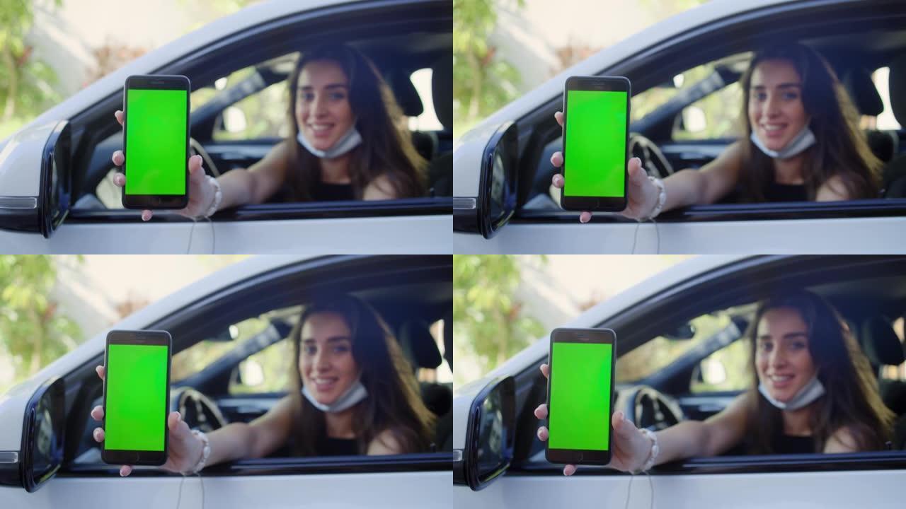 女司机使用手机上的数字疫苗护照应用程序。探出车窗。屏幕上的色度键