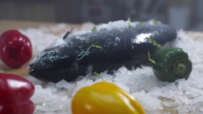 新鲜的全鱼和蔬菜躺在碎冰上。准备做饭