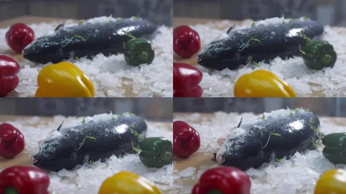 新鲜的全鱼和蔬菜躺在碎冰上。准备做饭
