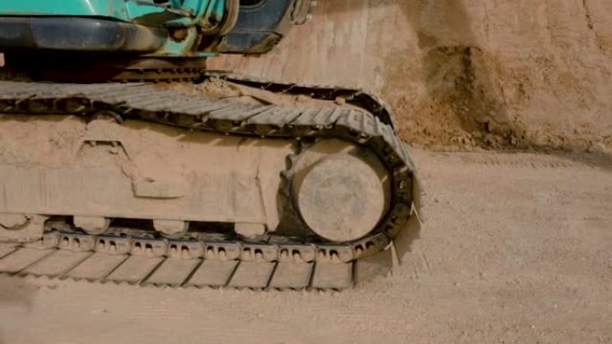 4K，关闭停在建筑工地的大型反铲挖土机的钢轮。大型履带式车轮由钢制装载机部件制成。