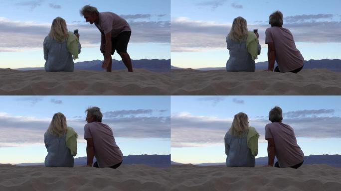 夫妇在沙漠中的沙丘上放松