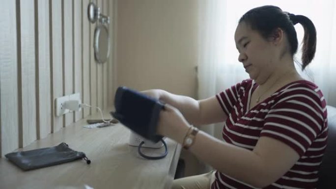 亚洲妇女在家中测量血压