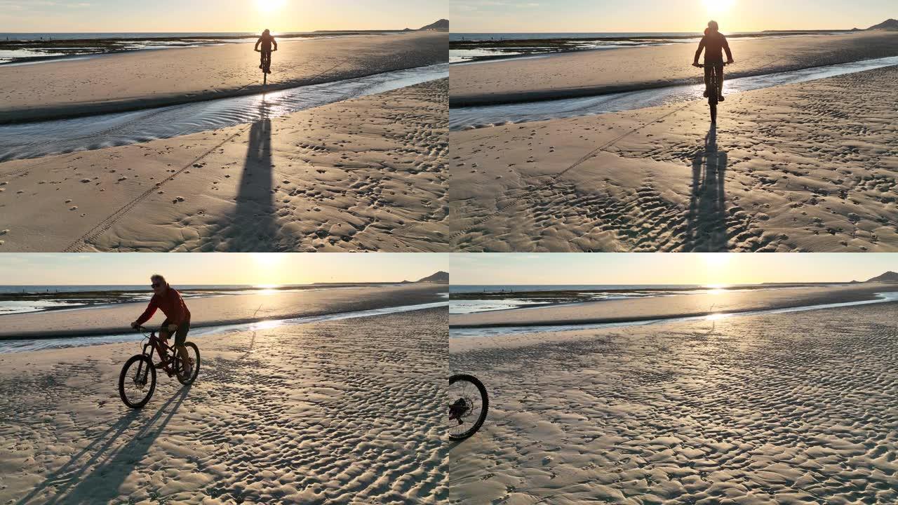 男子在空旷的海滩上骑自行车的鸟瞰图