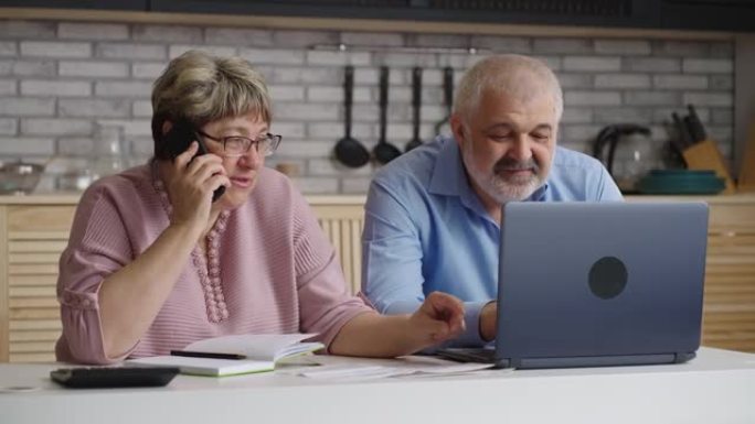 老年男女正在通过电话咨询金融和保险顾问，妇女正在通过电话交谈