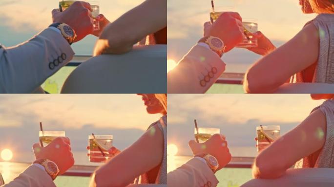 日落时，SLO MO男人和女人在游艇上碰碰鸡尾酒杯