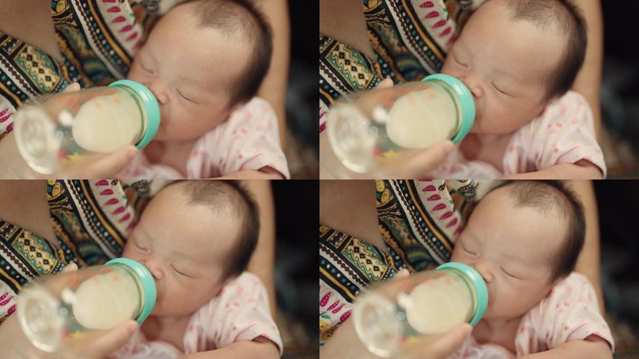慈爱的母亲在家用奶瓶喂养新生的儿子