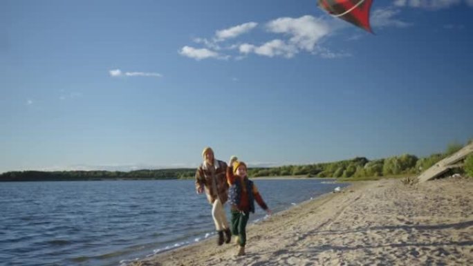 一对母女在岸上一起放风筝。母女俩一起跑风筝