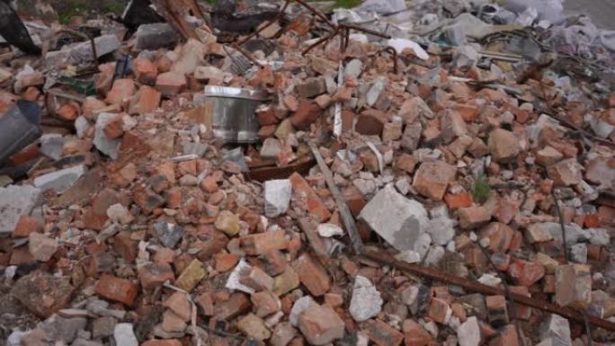 在户外被炸毁的城市里，地面上的砖块和金属。空袭轰炸后，乌克兰小镇的近场残破房屋残渣。慢动作。