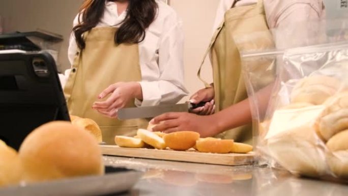 两名创业厨师现场直播秀，演示在厨房切片面包。