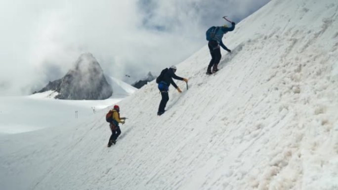 在雪坡上攀登。雄伟的欧洲阿尔卑斯山。登山探险的高级登山者，遥远的轮廓